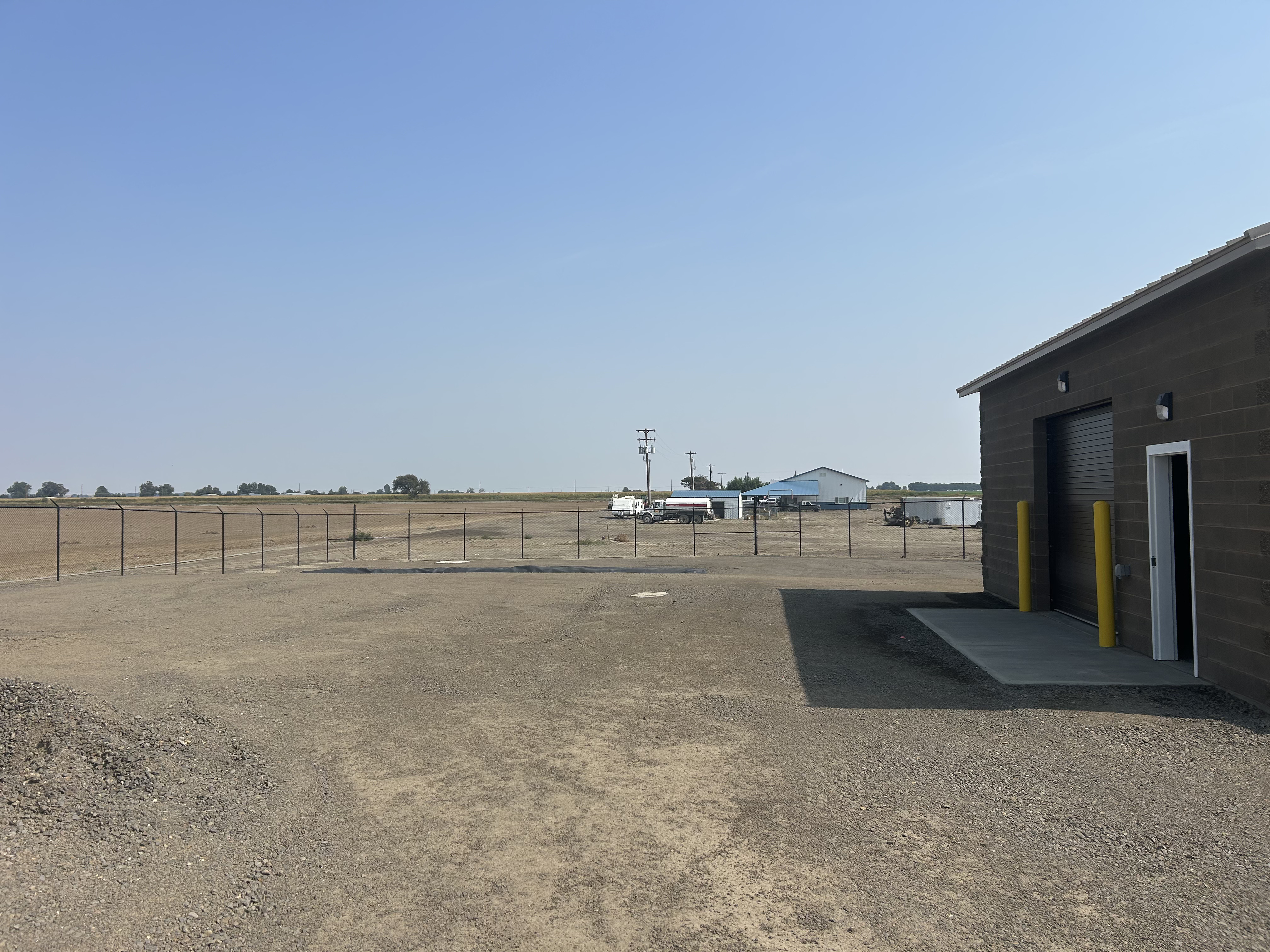Completed water treatment facility — CMU pump house and concrete tank with fencing
